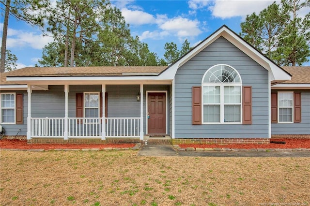 ranch-style home with covered porch and a front yard