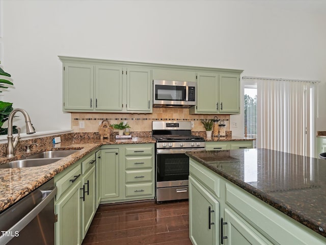 kitchen featuring appliances with stainless steel finishes, green cabinets, and a sink