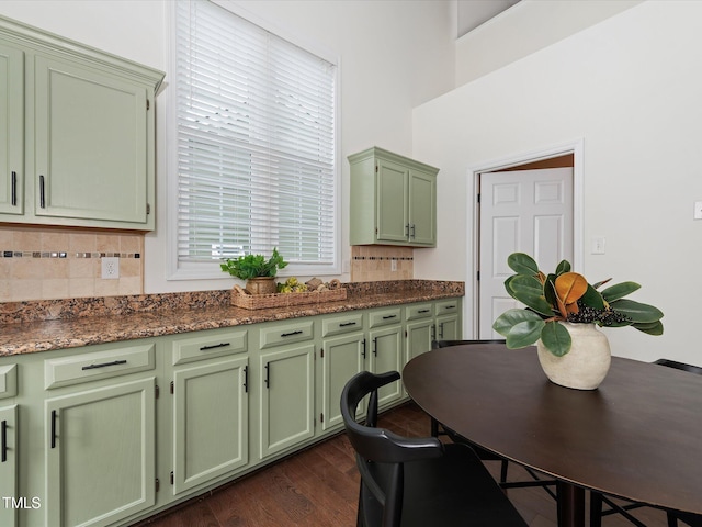 kitchen featuring dark wood-style floors, decorative backsplash, dark countertops, and green cabinetry