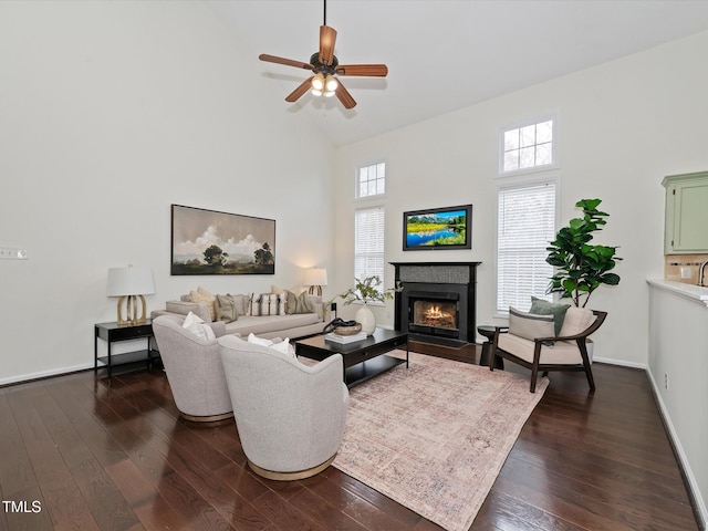 living area with a fireplace with flush hearth, high vaulted ceiling, dark wood finished floors, and a ceiling fan