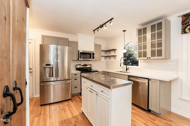 kitchen featuring open shelves, light wood-style flooring, a sink, gray cabinetry, and stainless steel appliances