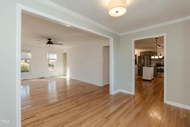 spare room featuring baseboards, ceiling fan with notable chandelier, ornamental molding, and light wood finished floors