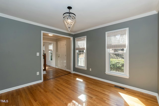 unfurnished room with light wood finished floors, visible vents, baseboards, a chandelier, and ornamental molding