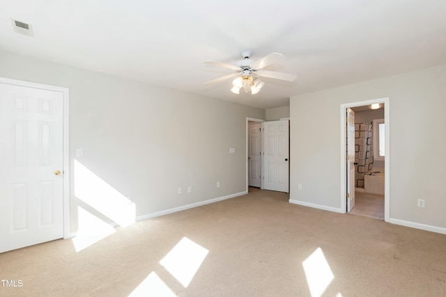 unfurnished bedroom featuring ensuite bath, a ceiling fan, baseboards, and carpet floors