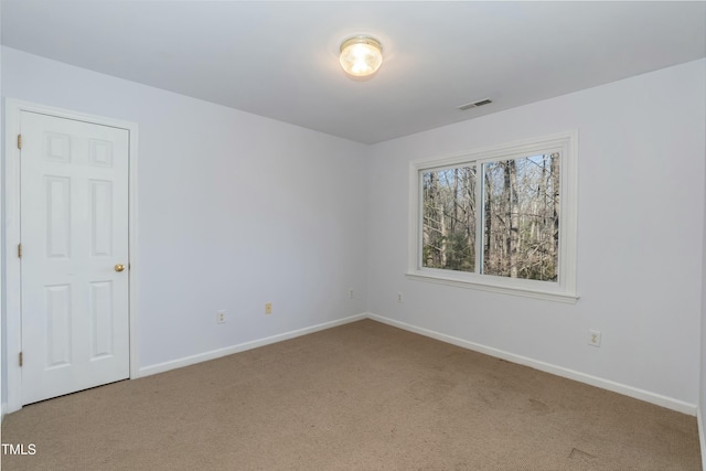 carpeted empty room featuring visible vents and baseboards