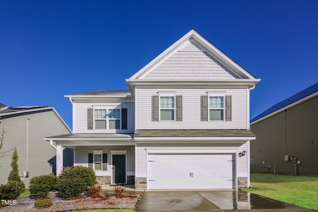 craftsman-style home with stone siding, covered porch, concrete driveway, and an attached garage