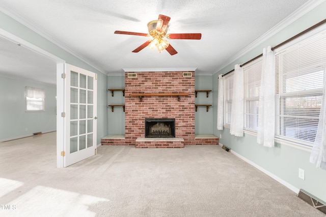 unfurnished living room featuring visible vents, crown molding, ceiling fan, carpet floors, and a fireplace