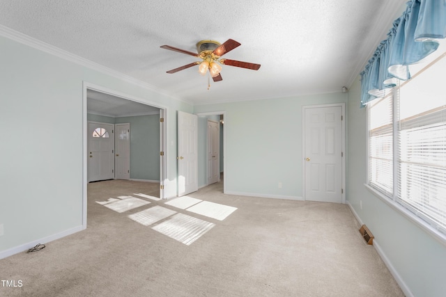 unfurnished bedroom with light colored carpet, a textured ceiling, and ornamental molding