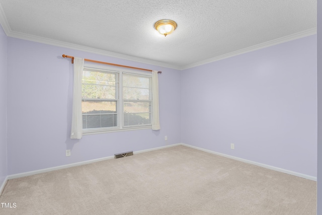 carpeted spare room featuring visible vents, baseboards, and ornamental molding