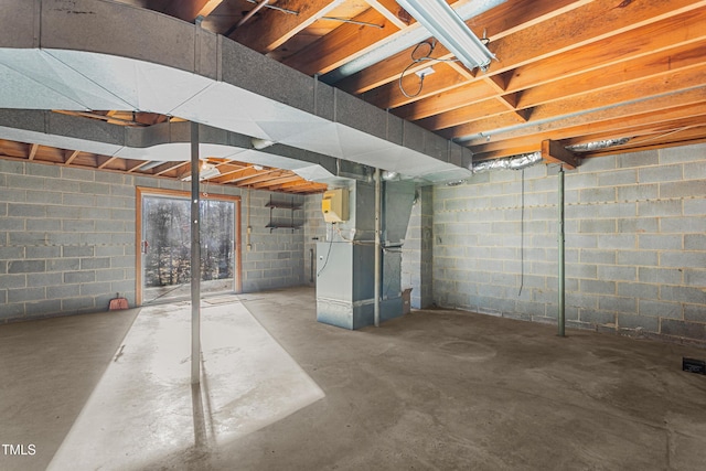 basement featuring heating unit and concrete block wall
