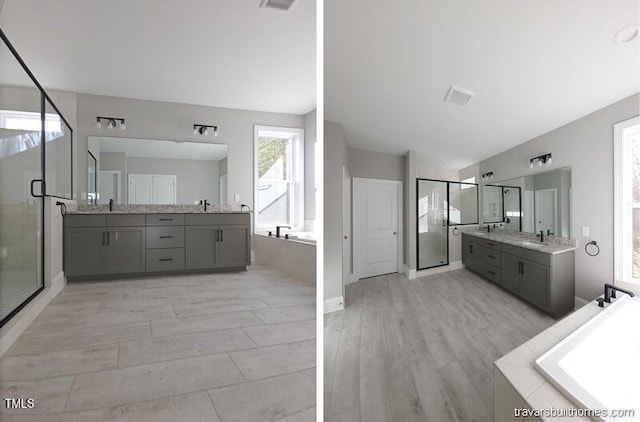 full bath featuring a stall shower, two vanities, a garden tub, and a sink