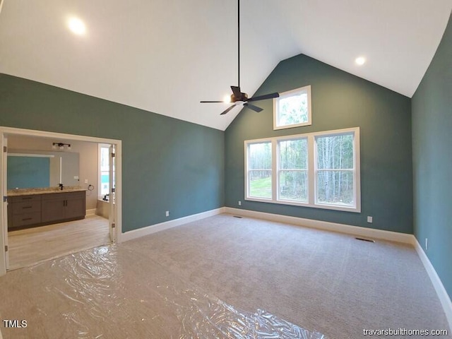 unfurnished bedroom with visible vents, high vaulted ceiling, ensuite bathroom, baseboards, and ceiling fan