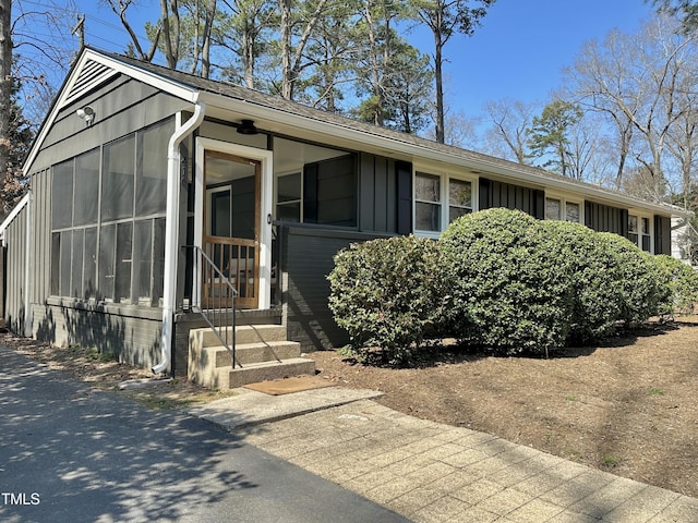 view of front of home with a sunroom, board and batten siding, and entry steps