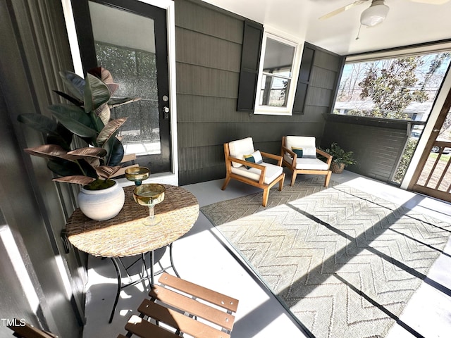 sunroom / solarium featuring a ceiling fan