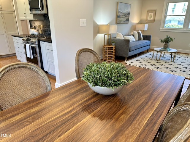 dining space with baseboards and light wood-type flooring