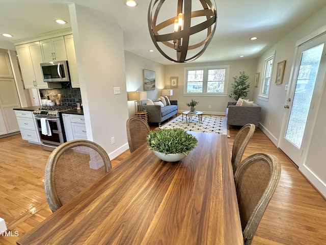 dining room with recessed lighting, light wood-style flooring, and baseboards