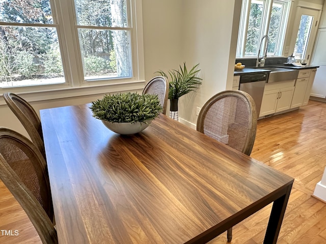 dining area with baseboards and light wood-style flooring