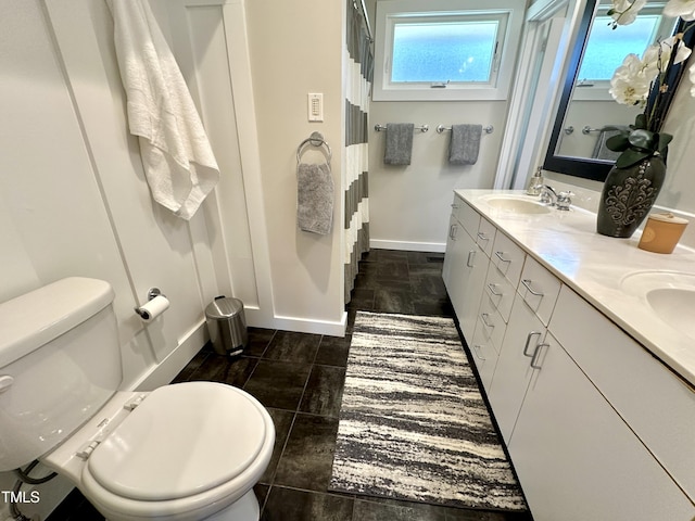 full bath featuring a sink, baseboards, plenty of natural light, and toilet