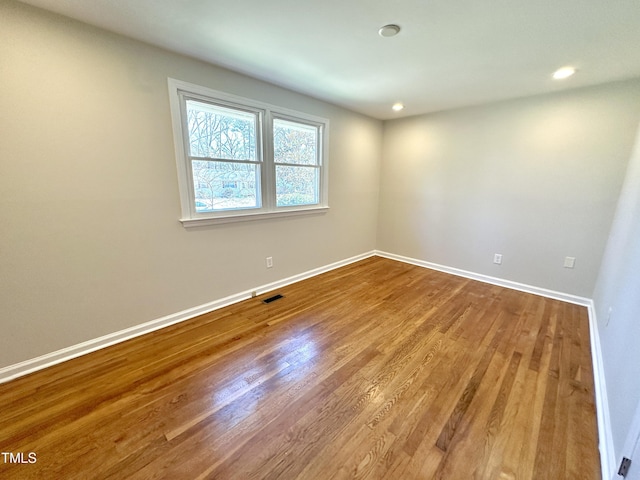 spare room featuring recessed lighting, visible vents, baseboards, and wood finished floors