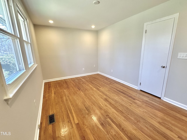 empty room with visible vents, baseboards, and wood finished floors