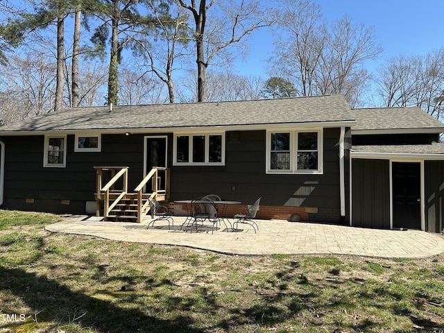 rear view of house with crawl space, a patio area, a yard, and roof with shingles