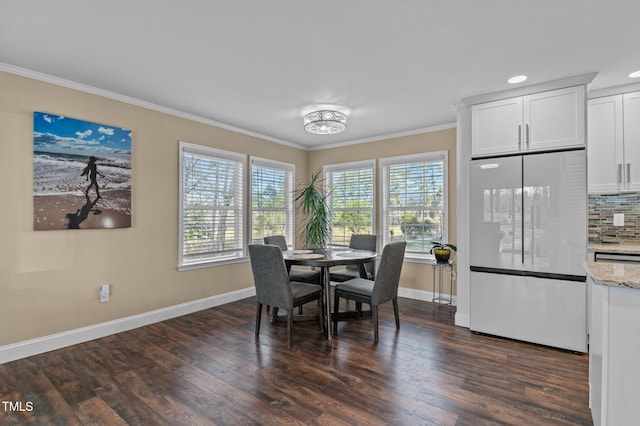 dining room with dark wood-style flooring, a wealth of natural light, and ornamental molding