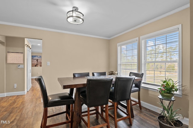 dining area featuring wood finished floors, baseboards, and ornamental molding