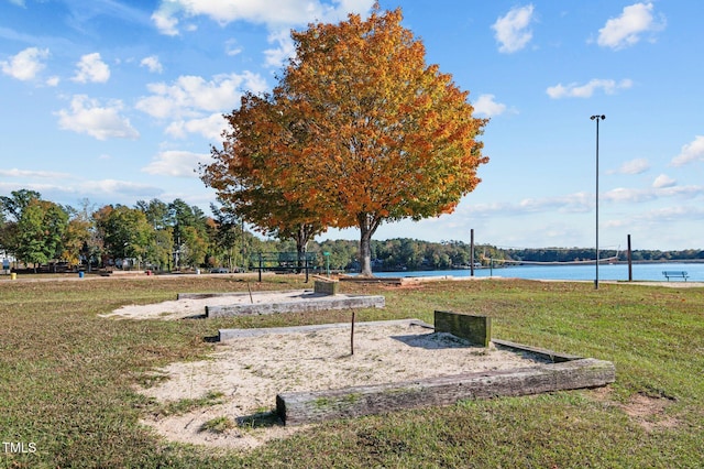 view of home's community featuring a lawn and a water view