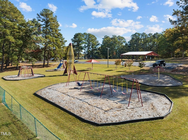 community jungle gym featuring a yard and fence