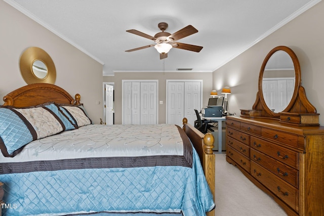 bedroom with visible vents, two closets, crown molding, light colored carpet, and ceiling fan