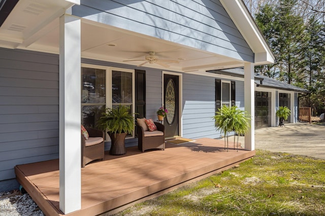 view of exterior entry featuring a garage, driveway, and ceiling fan