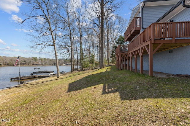 view of yard with a deck with water view and a dock