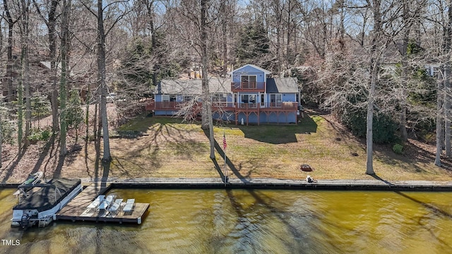 exterior space featuring a deck with water view and a lawn