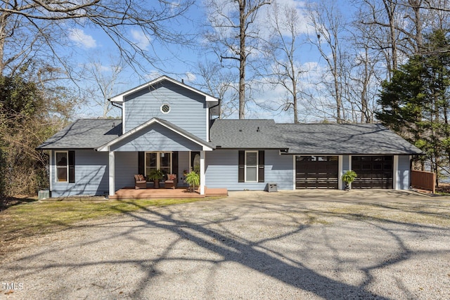 view of front of property with aphalt driveway, roof with shingles, and an attached garage