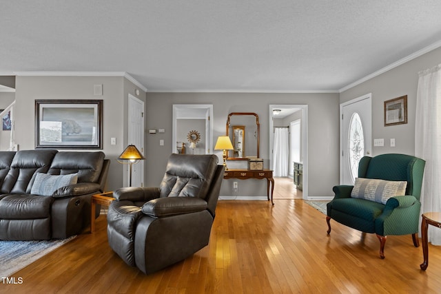 living room with baseboards, ornamental molding, and light wood finished floors