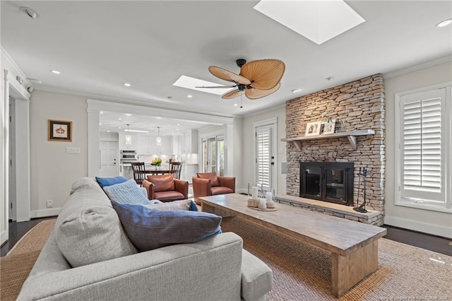 1906 Partridge Dr, Fayetteville, NC 28304 - living room with wood finished floors, a fireplace, a skylight, and ornamental molding