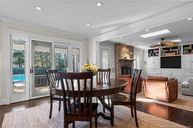 1906 Partridge Dr, Fayetteville, NC 28304 - dining room featuring a stone fireplace, a skylight, dark wood finished floors, and ornamental molding