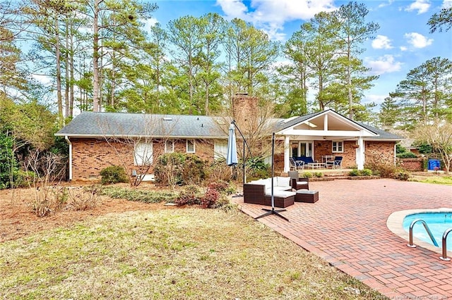 1906 Partridge Dr, Fayetteville, NC 28304 - rear view of house with a patio, brick siding, a chimney, and outdoor lounge area