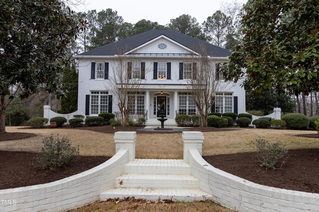 greek revival inspired property featuring a front lawn