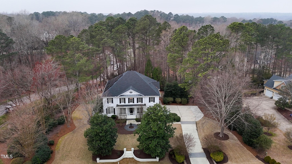 bird's eye view with a wooded view