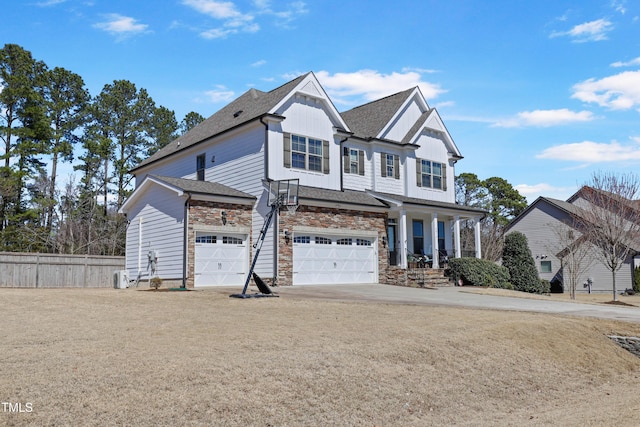 view of front of home with board and batten siding, fence, roof with shingles, stone siding, and driveway