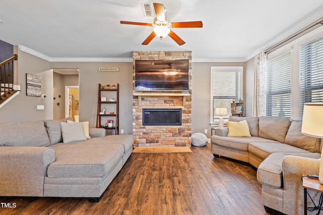 living area featuring stairway, dark wood-style flooring, a fireplace, and ornamental molding