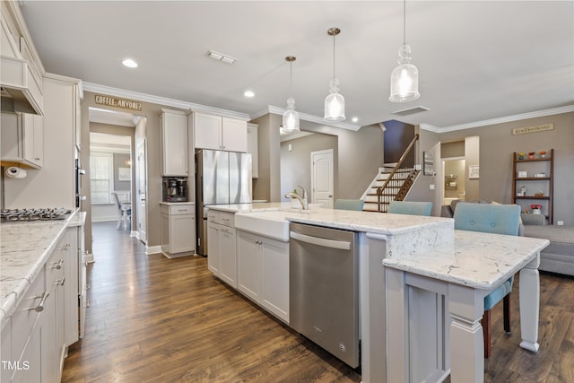 kitchen featuring visible vents, crown molding, dark wood-type flooring, stainless steel appliances, and a sink