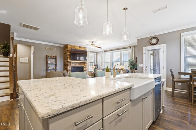 kitchen with a fireplace, a ceiling fan, visible vents, and ornamental molding