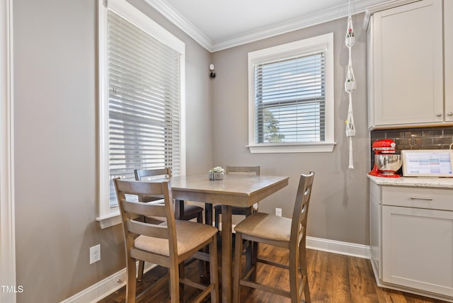 dining room with dark wood-style flooring, a healthy amount of sunlight, baseboards, and ornamental molding