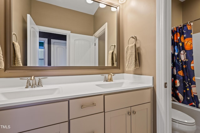 bathroom with double vanity, toilet, shower / bath combo, and a sink