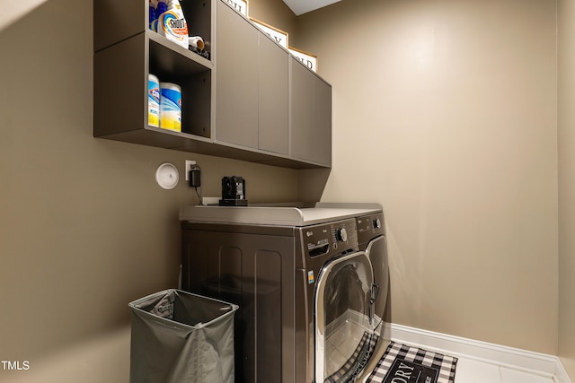 washroom with separate washer and dryer, cabinet space, and baseboards