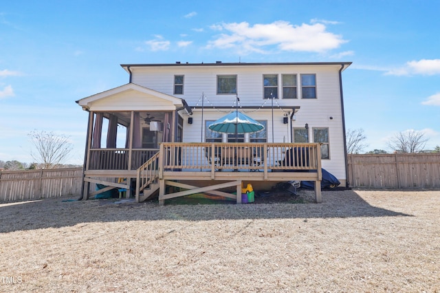 back of house with a wooden deck, a fenced backyard, and a sunroom