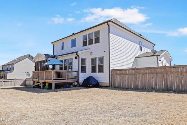 back of property with a fenced backyard and a deck