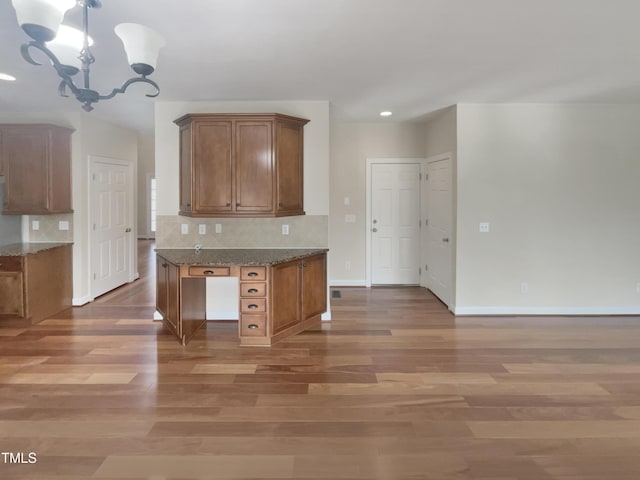 kitchen featuring brown cabinetry, tasteful backsplash, and light wood finished floors